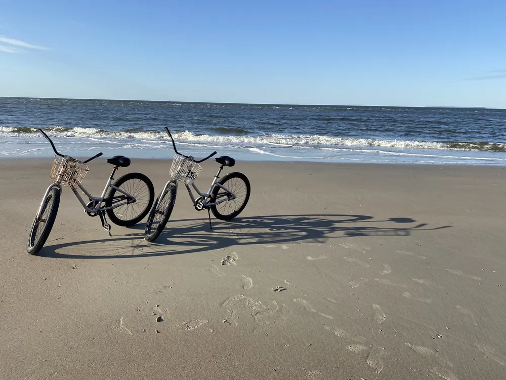 Two beach cruisers side by side on the sand