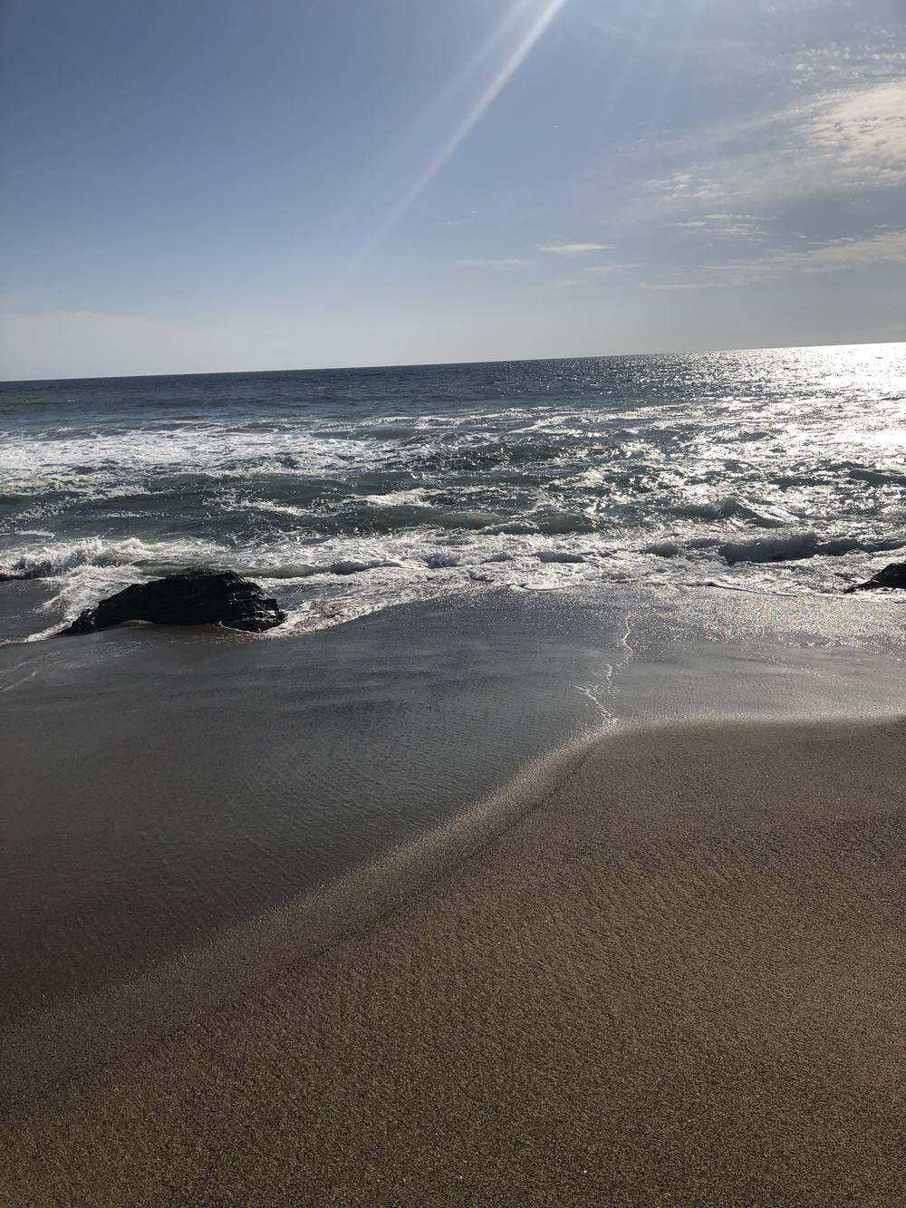 Waves washing over wet sand on a sunny beach