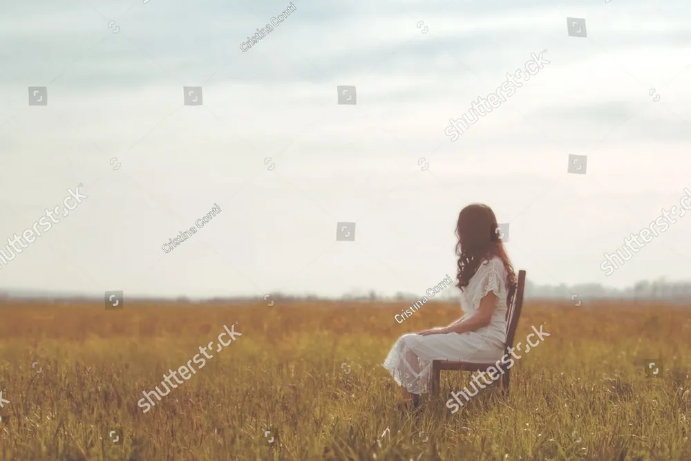 A woman sitting alone in a golden field