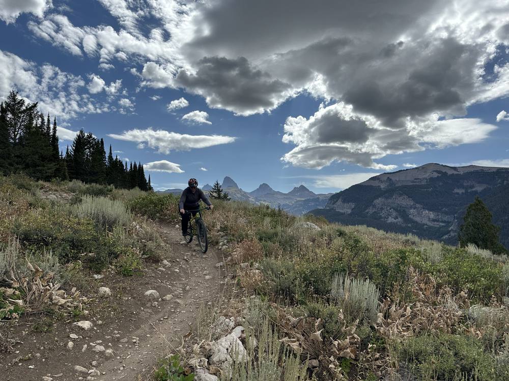 A mountain biker on a trail below the Tetons